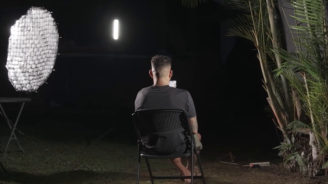 Night falls on the backyard interview; a softbox and LED light Yancy in his chair